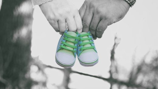 Frau und Mann halten Babyschuhe in den Händen