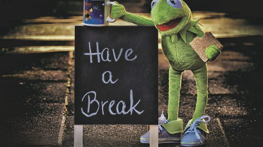 Kermit, der Frosch, lehnt an einem Schild mit der Aufschrift "Have a Break".